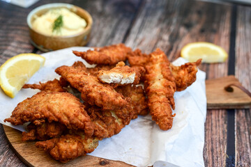 
 Crispy  deep fried   Chicken strips and wedges potato. Breaded  with cornflakes chicken  Breast fillets  with chilly peppers and fresh   basil on wooden rustic background