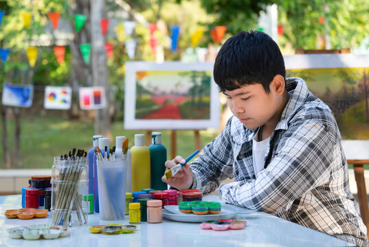 asian teens boy mixing color for painting in school art club. concept of school elective activities, art talent ability