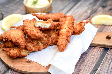 
 Crispy  deep fried   Chicken strips and wedges potato. Breaded  with cornflakes chicken  Breast fillets  with chilly peppers and fresh   basil on wooden rustic background