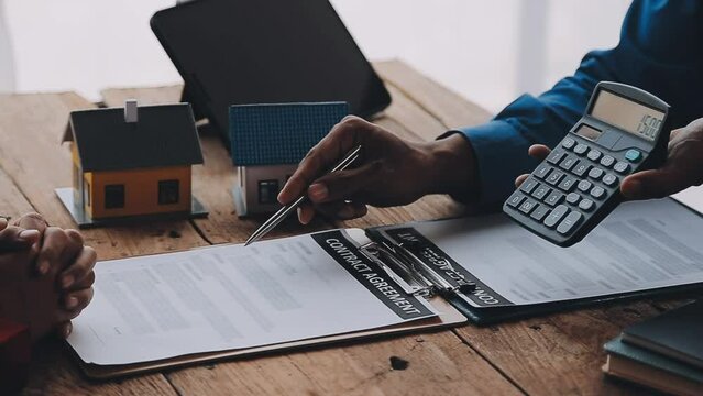 Real estate broker agent presenting and consult to customer to decision making sign insurance form agreement, buy and sell home model, concerning mortgage loan offer for and house insurance