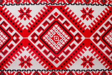 Embroidered fabric with red and black details on a white background, cubes and various mosaics as a decorative background