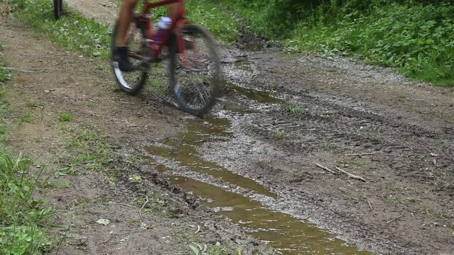 Bicycle Tires Splash through Mud Puddle
