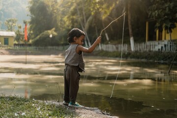 A young boy is fishing in a pond in Guwahati Assam