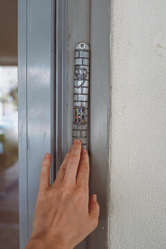 Woman touches mezuzah on the door