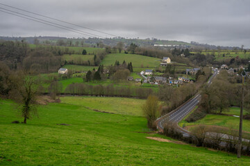 Several houses and green meadows. highway. Countryside in France.