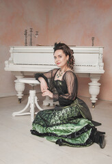 Beautiful young smiling woman wearing medieval vintage Victorian Style dress sitting on the floor...