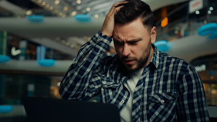 Disappointed depressed sad businessman freelancer caucasian man has problem with computer make...