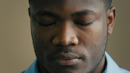 Fototapeta premium Angry serious man face close up headshot african american 30s businessman worker employee salesman adult ethnic male portrait indoors looking at camera sadness expression loss business health problem