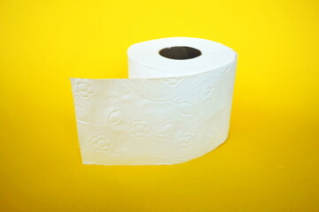 Roll of toilet paper on the yellow background. Tissue for use in the toilet room, used for cleaning the dirt in the bathroom. People are stocking up toilet paper for home.