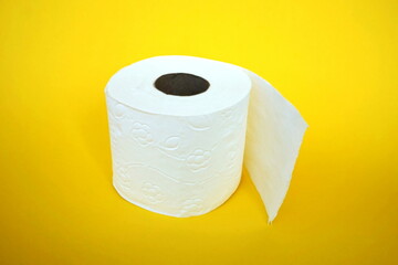 Roll of toilet paper on the yellow background. Tissue for use in the toilet room, used for cleaning the dirt in the bathroom. People are stocking up toilet paper for home.