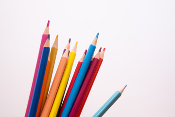 Colorful pencils on wooden background, card with school or office stationery on white