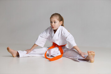 Fototapeta Girl child sits on a twine in a kimono on a white background. obraz