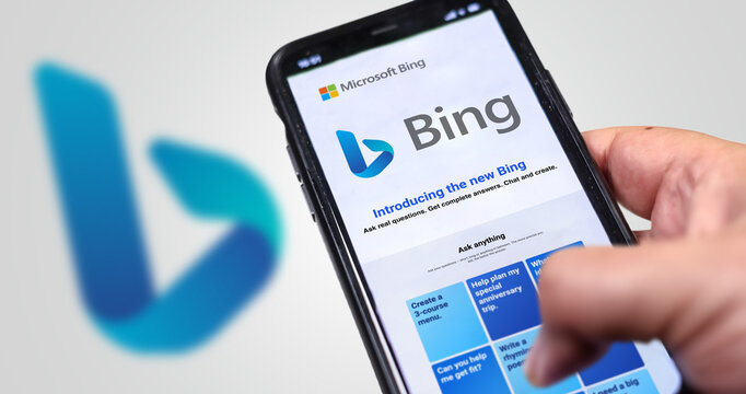A hand holding a phone with the Microsoft Bing website on the screen