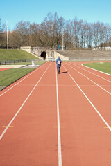 walking girl on running track in the stadium