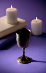 golden christian chalice with candles and purple background