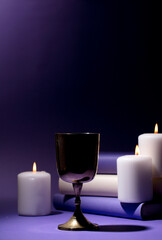 golden christian chalice silhouette with candles and flame and purple background