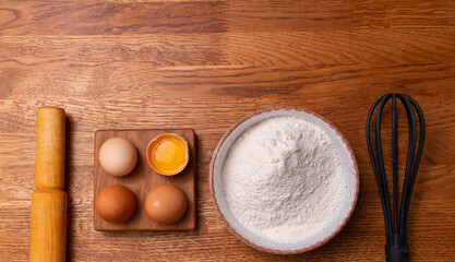Flour on a wooden background with a rolling pin. The concept of cooking