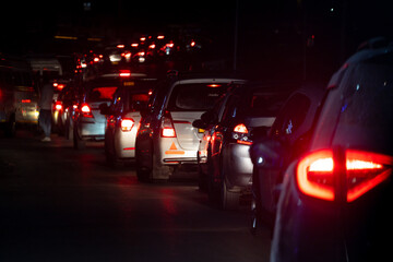 Night shot of car lights stuck for large distance in traffic jam at night on a narrow road in the...