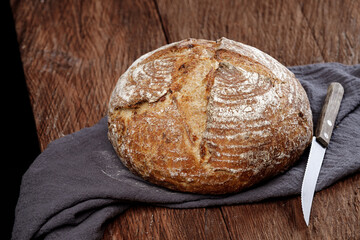 Traditional wheat rustic sourdough bread on a wooden table.
