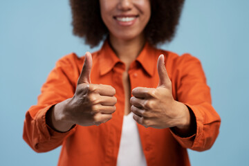Cropped portrait of happy excited woman showing thumbs up gesture