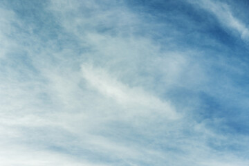 A large swirl of fluffy clouds scattered by the wind in a deep blue sky. Vector cotton texture background