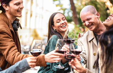 Trendy people having fun drinking red wine out side at city winery bar - Happy friends sharing...