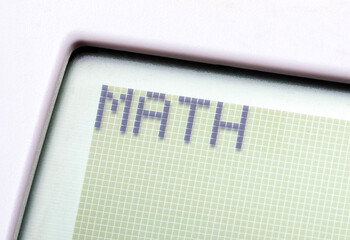 A single word MATH on a graphing calculator digital display, object macro, detail, extreme closeup, nobody. Mathematics, computer science and technology education abstract concept, learning maths