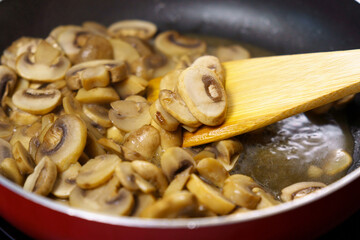 Mushroom champignon soup is cooked. Mushrooms are boiling close-up.