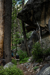 Backpackers Hike Under Overhanging Boulders in the Grand Canyon of the Tuolumne