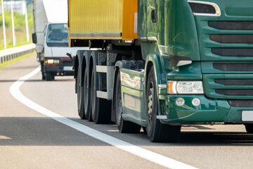Generic simple commercial transport truck driving through a road, highway, wheels closeup. Products, land vehicle goods transportation, delivery logistics, shipping, business, finance, news thumbnail