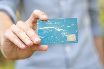 Man holding a blue premium VIP social club membership advantage card in hand, empty template,...