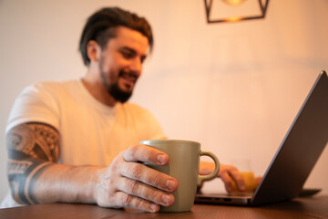 Handsome young man working on his laptop at home