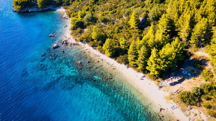 The stunning beauty of Croatia's rocks and forests is captured in this breathtaking aerial view. Take in the turquoise waters and beach from above, and add this travel image to your collection of unfo