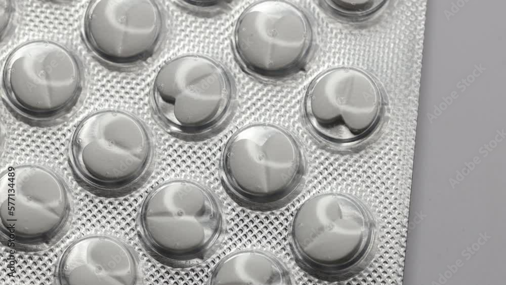 Poster white pills in the shape of a heart in a blister are rotated in a circle
