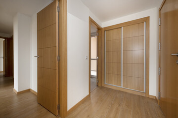 Entrance hall of an empty house with an oak access door to match the rest of the doors, a built-in...