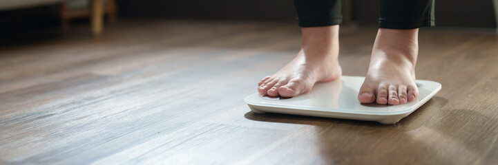 Woman feet standing on digital scales for diet control..