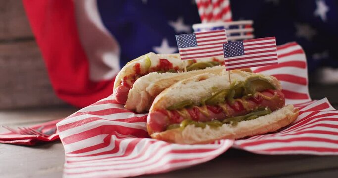 Video of hot dogs with mustard and ketchup over flag of usa on a wooden surface