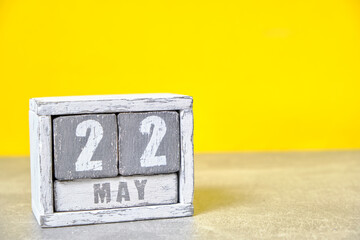 May 22 calendar made wooden cubes yellow background.With an empty space for your text.