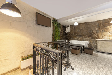 A bar room with Chester style sofas and a black metal wrought iron railing, a black square coffee...