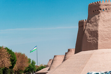 Uzbekistan waving flag near old city Khiva ancient walls