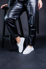 Female legs in leather pants and black leather boots. Women's casual leather spring boots. Stylish shoes for women