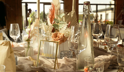 Wedding table decoration with flower arrangements and tableware.