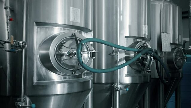 cylindrical conical fermentation tanks in workshop of beverage plant, stainless steel tun