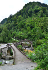 Fototapeta na wymiar Located in the city of Artvin, Turkey, the Double Bridge was built in the 18th century. Bridges consist of a single eye and are positioned at approximately 90 degrees to each other.
