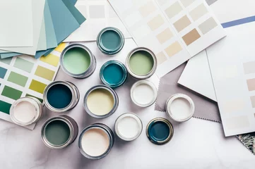 Tiny sample paint cans during house renovation, process of choosing paint for the walls, different green and beige colors, color charts on background © manuta