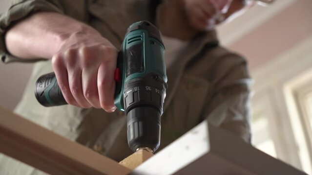 male craftsman works in a workshop with wood. power tool. close-up
