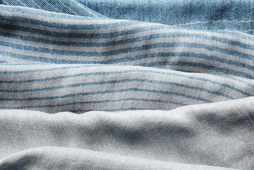 Background with draped blue gray cotton fabric, napkin, striped tablecloth or scarf
