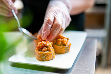 professional chef's hands making sushi and rolls in a restaurant kitchen