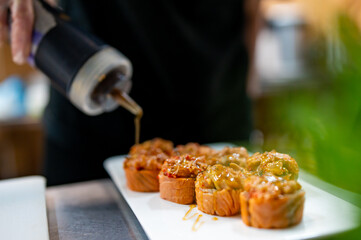 professional chef's hands making sushi and rolls in a restaurant kitchen