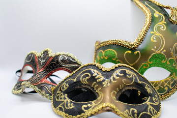 Sparkling masquerade ball masks against a white background with space for copy